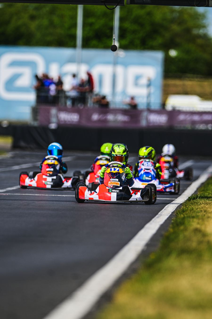 Pack of Rotax E10 karts racing towards the camera